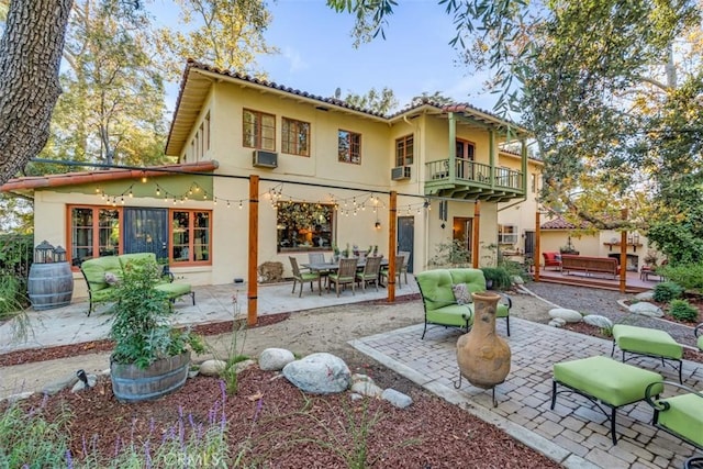 rear view of house featuring a balcony, a patio area, cooling unit, and an outdoor hangout area