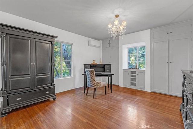 living area featuring hardwood / wood-style floors, an inviting chandelier, and a wall mounted air conditioner