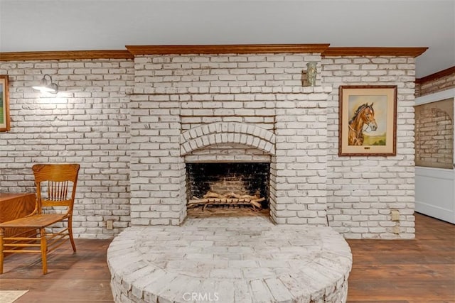 sitting room with a fireplace, crown molding, and hardwood / wood-style flooring