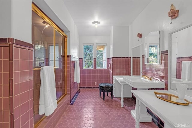 bathroom featuring tile walls, tile patterned floors, plenty of natural light, and sink