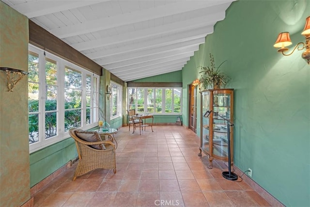 sunroom / solarium featuring a healthy amount of sunlight and lofted ceiling with beams