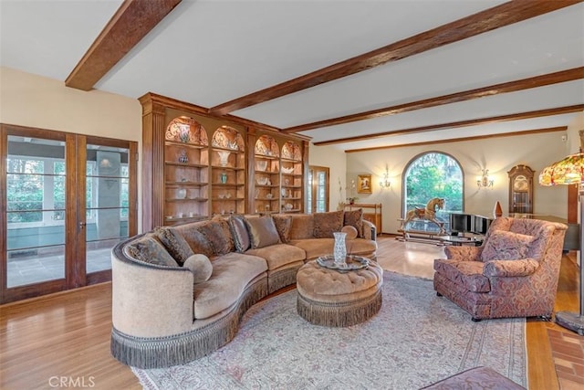 living room with french doors, beamed ceiling, and light hardwood / wood-style floors