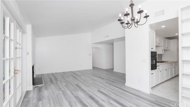 interior space with light wood-type flooring and an inviting chandelier