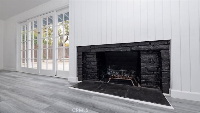 room details featuring a brick fireplace and wood-type flooring