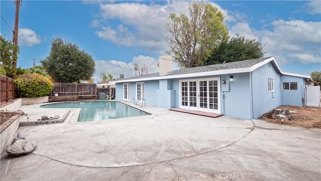 view of swimming pool with french doors and a patio area