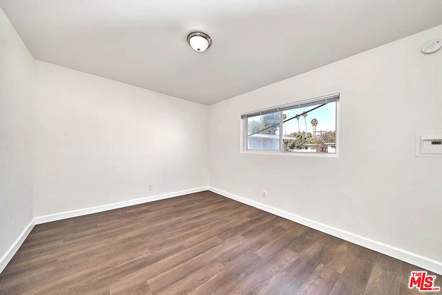 spare room with dark wood-type flooring