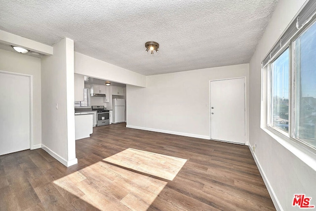 unfurnished living room with a textured ceiling and dark hardwood / wood-style flooring