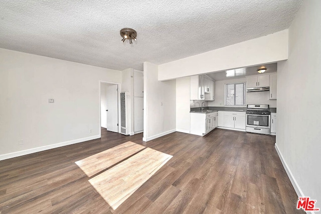 kitchen with stainless steel gas range oven, sink, white cabinetry, dark wood-type flooring, and a textured ceiling