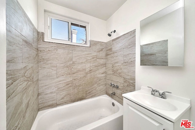 bathroom featuring tiled shower / bath combo and vanity