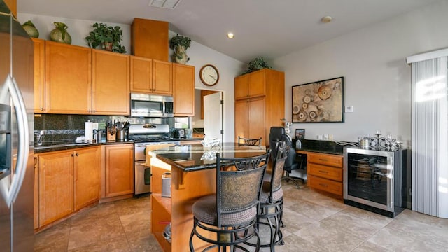 kitchen featuring wine cooler, tasteful backsplash, a center island, a kitchen bar, and stainless steel appliances