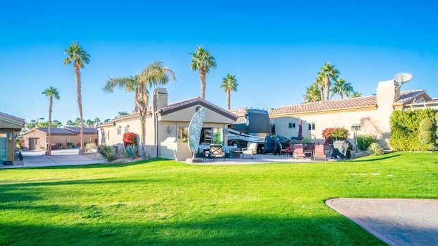 rear view of house with a yard and a patio