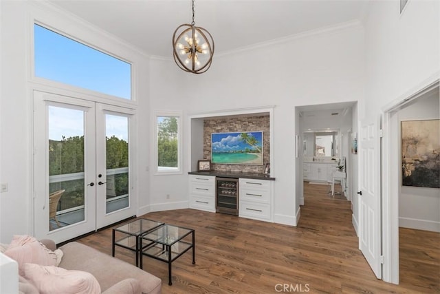 living room featuring dark wood-type flooring, an inviting chandelier, french doors, and wine cooler