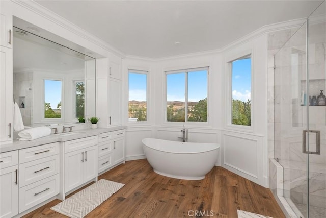 bathroom with hardwood / wood-style flooring, separate shower and tub, vanity, and ornamental molding