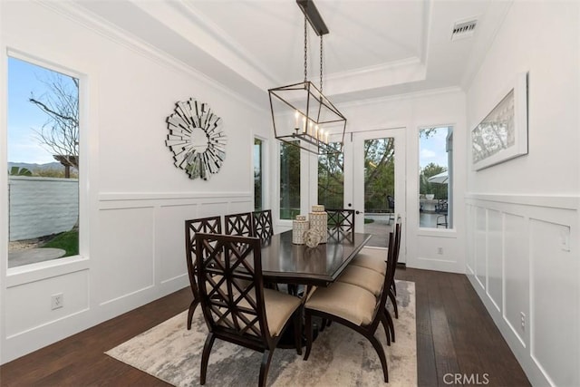 dining area with a notable chandelier, a water view, crown molding, and dark hardwood / wood-style flooring