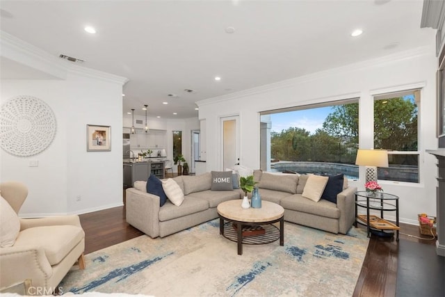 living room with dark wood-type flooring and ornamental molding