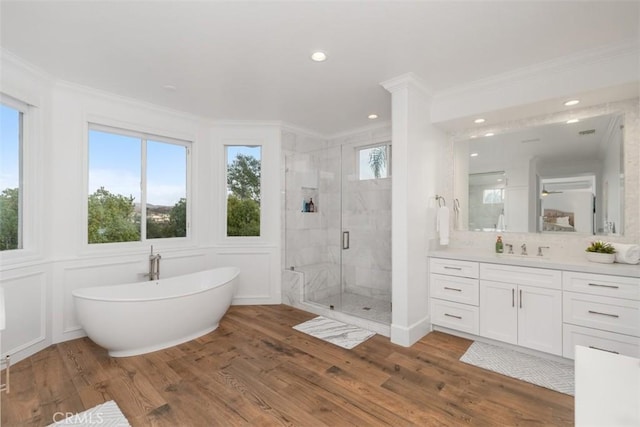 bathroom with crown molding, plenty of natural light, hardwood / wood-style flooring, and separate shower and tub