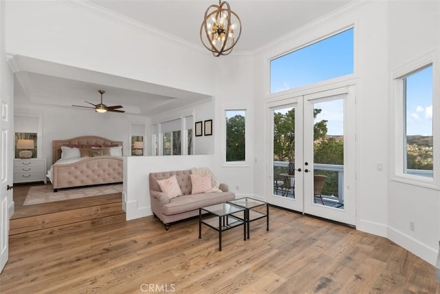 bedroom with french doors, light hardwood / wood-style floors, access to exterior, a notable chandelier, and crown molding