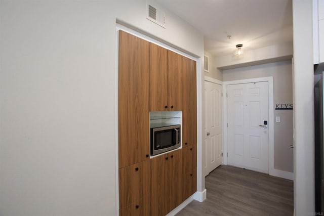 corridor with hardwood / wood-style flooring