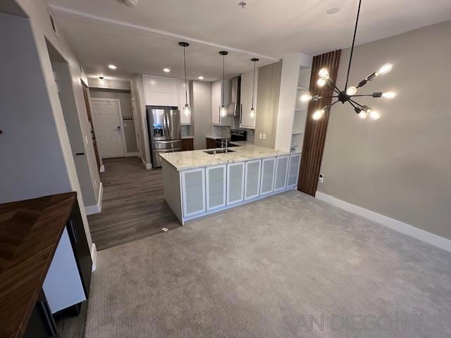 kitchen featuring stainless steel refrigerator with ice dispenser, white cabinetry, an inviting chandelier, hanging light fixtures, and kitchen peninsula