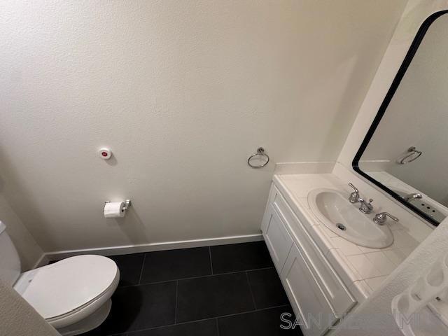 bathroom featuring tile patterned floors, vanity, and toilet