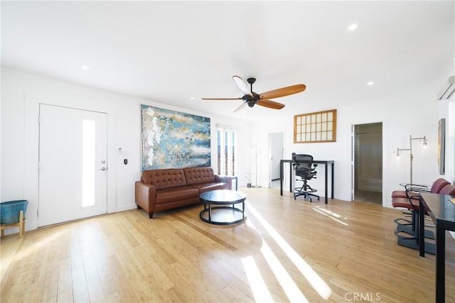 living room featuring ceiling fan and light hardwood / wood-style flooring