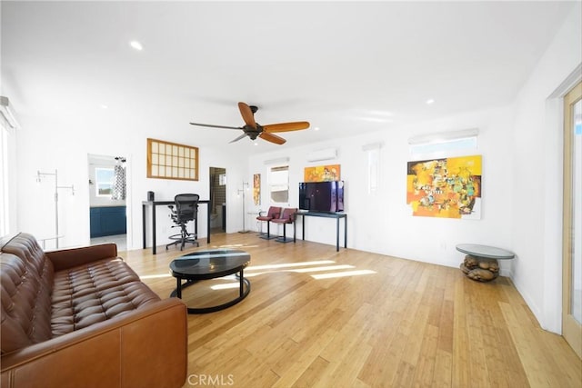 living room featuring ceiling fan and light hardwood / wood-style flooring