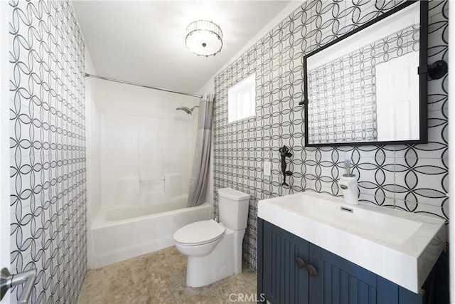 full bathroom with tile walls, toilet, vanity, and shower / tub combo with curtain