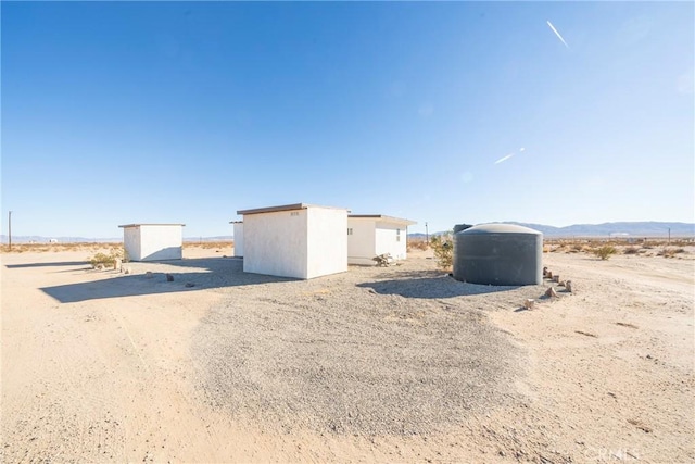 exterior space featuring a rural view, a mountain view, and a storage shed