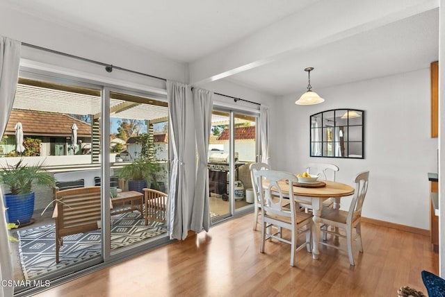 dining room featuring beam ceiling and wood-type flooring