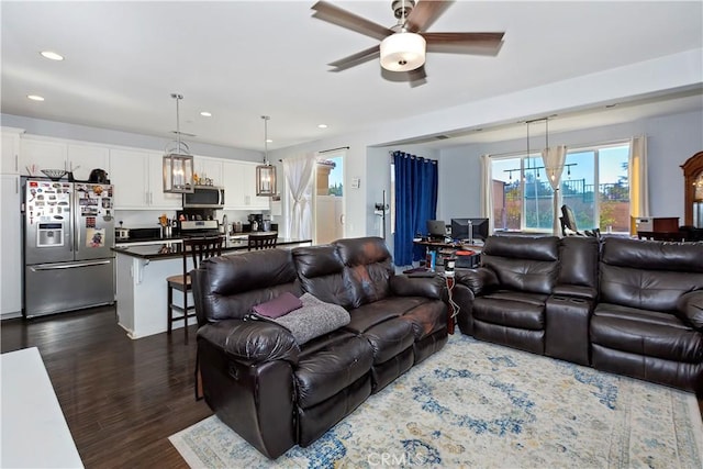 living room featuring ceiling fan, dark hardwood / wood-style flooring, and sink