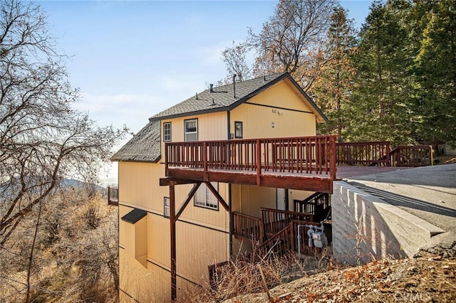 2477 Spring Oak Dr, Running Springs, CA 92382 - rear view of house featuring a wooden deck, roof with shingles, and stairway