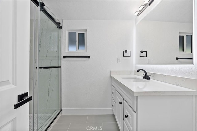 bathroom featuring walk in shower, vanity, and tile patterned flooring