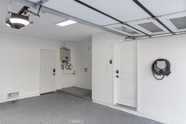 garage featuring water heater and a garage door opener