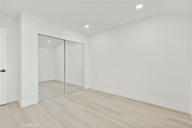 unfurnished bedroom with a closet and light hardwood / wood-style flooring