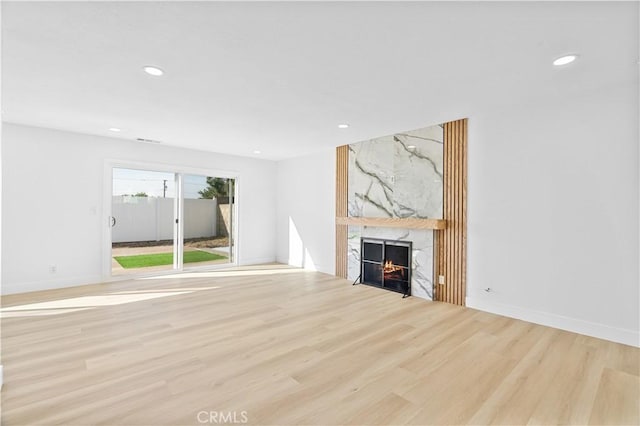 unfurnished living room with light hardwood / wood-style flooring and a premium fireplace