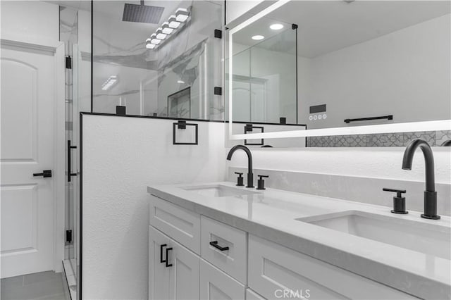 bathroom with a shower with shower door and vanity