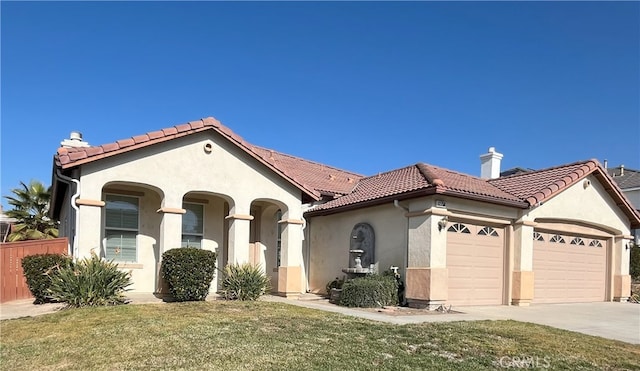 mediterranean / spanish house featuring a garage and a front lawn