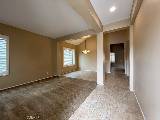 interior space with light tile patterned flooring, vaulted ceiling, and a notable chandelier