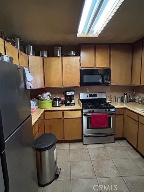 kitchen with light tile patterned floors and appliances with stainless steel finishes