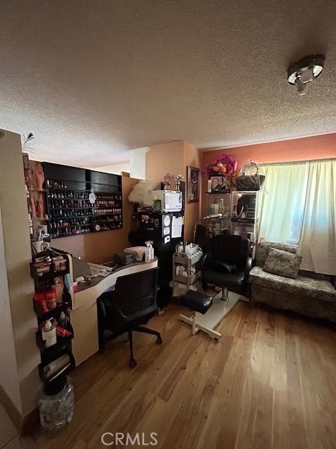 home office featuring a textured ceiling and hardwood / wood-style flooring