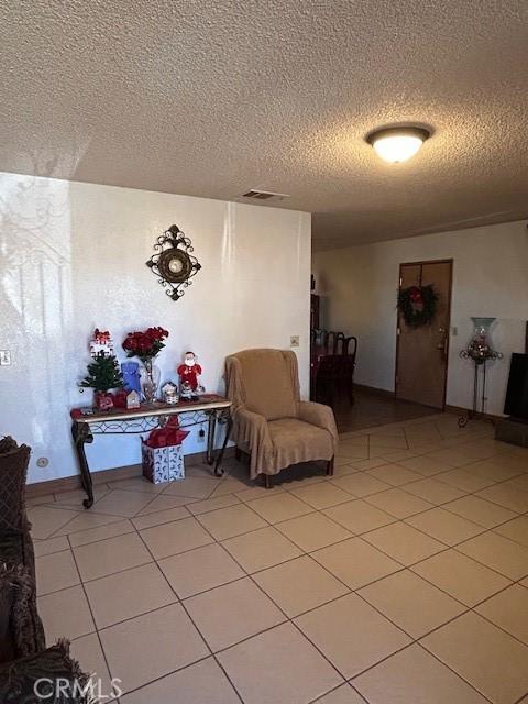 sitting room with a textured ceiling and tile patterned flooring