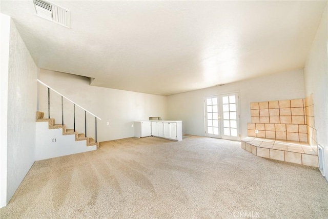 unfurnished living room with carpet and french doors