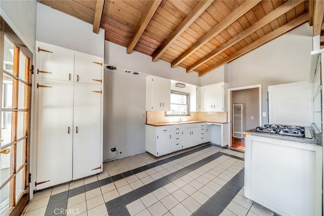 kitchen featuring wood ceiling, white cabinetry, beamed ceiling, high vaulted ceiling, and light tile patterned floors