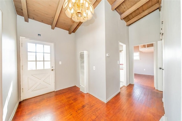 foyer entrance featuring beam ceiling, wood ceiling, an inviting chandelier, and high vaulted ceiling