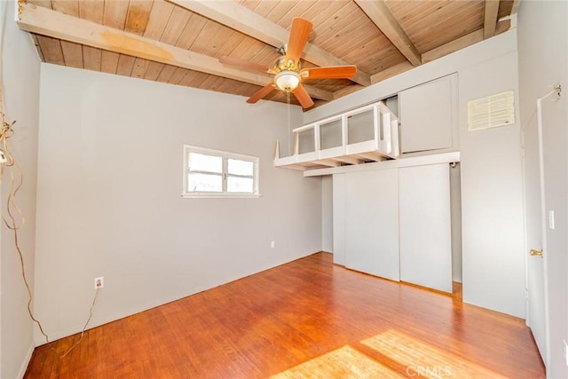 unfurnished bedroom featuring a closet, wood ceiling, wood-type flooring, and beamed ceiling