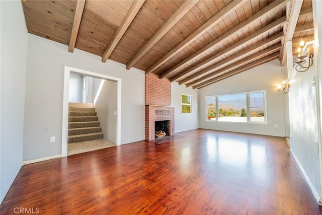 unfurnished living room featuring a fireplace, wood ceiling, beamed ceiling, and high vaulted ceiling