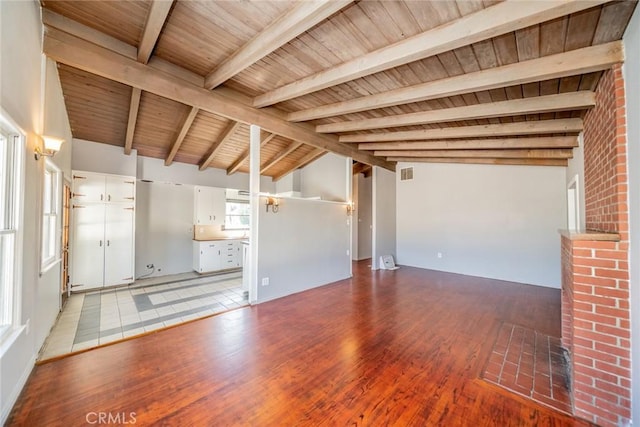 unfurnished living room with wooden ceiling, light hardwood / wood-style floors, beam ceiling, and high vaulted ceiling