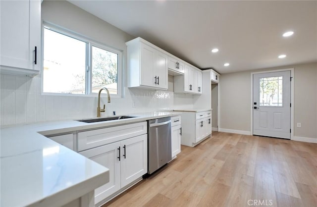 kitchen with white cabinetry, tasteful backsplash, light wood-type flooring, dishwasher, and sink