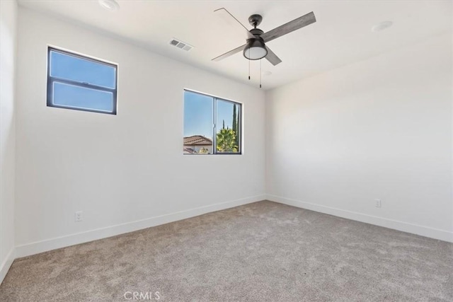 carpeted spare room featuring ceiling fan