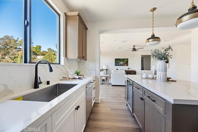 kitchen featuring pendant lighting, beverage cooler, dark hardwood / wood-style flooring, sink, and backsplash